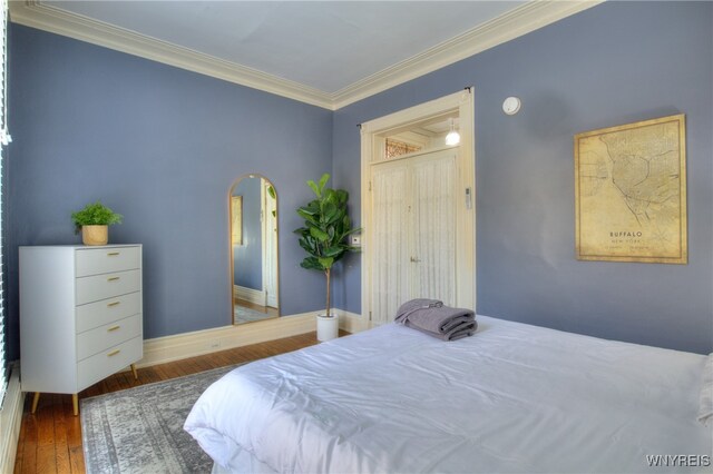 bedroom featuring ornamental molding and dark hardwood / wood-style flooring