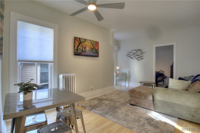 living room with radiator heating unit, wood-type flooring, and ceiling fan