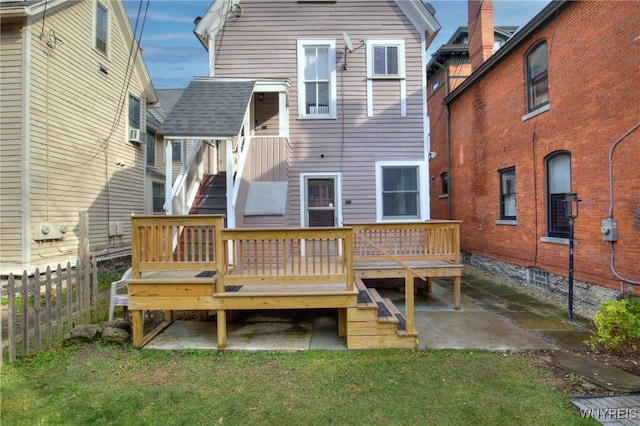 back of property featuring a patio, a wooden deck, and a lawn