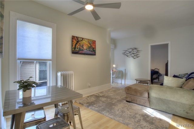 living room featuring radiator, ceiling fan, and wood-type flooring