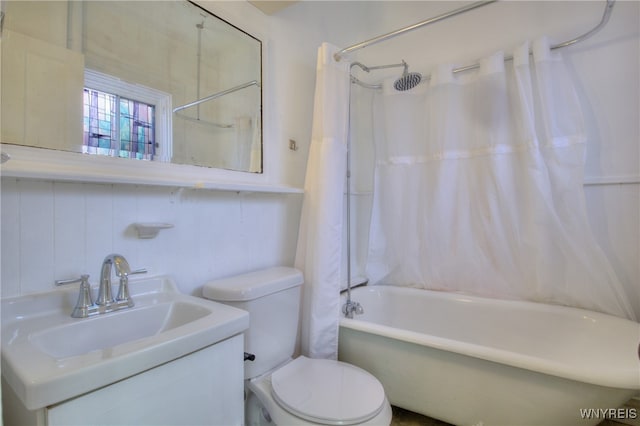 full bathroom with vanity, toilet, tile walls, and shower / tub combo with curtain