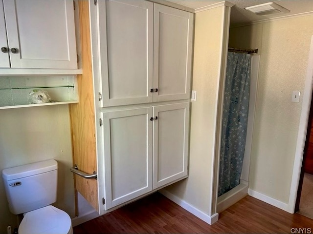 bathroom featuring toilet, wood-type flooring, and a shower with shower curtain