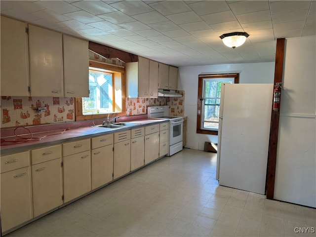 kitchen featuring white appliances, cream cabinetry, and sink