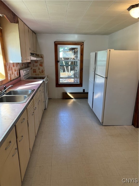 kitchen with backsplash, white appliances, and sink