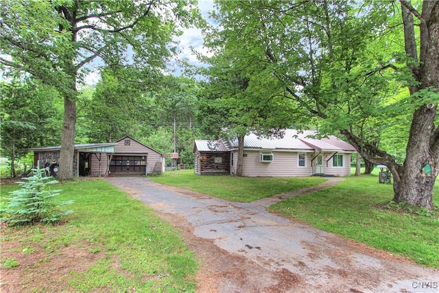6736 Pine Grove Rd, Watson, NY 13343 - view of front of house with an outbuilding, a front lawn, a metal roof, and asphalt driveway