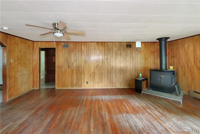 6736 Pine Grove Rd, Watson, NY 13343 - unfurnished living room featuring wood-type flooring, a wood stove, a ceiling fan, and wood walls