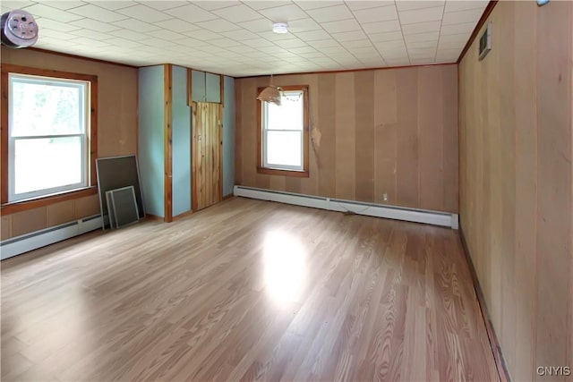 6736 Pine Grove Rd, Watson, NY 13343 - unfurnished room with a baseboard radiator, healthy amount of natural light, light wood finished floors, and wood walls
