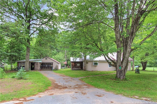 6736 Pine Grove Rd, Watson, NY 13343 - view of property exterior with asphalt driveway, an outbuilding, a lawn, and a metal roof