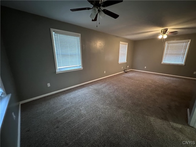 empty room featuring dark colored carpet and ceiling fan