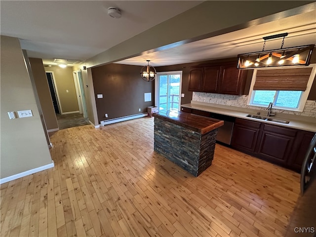 kitchen with decorative backsplash, dark brown cabinets, sink, a baseboard radiator, and light hardwood / wood-style floors