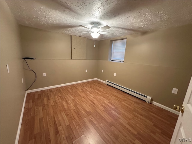 spare room with a baseboard heating unit, hardwood / wood-style flooring, a textured ceiling, and ceiling fan