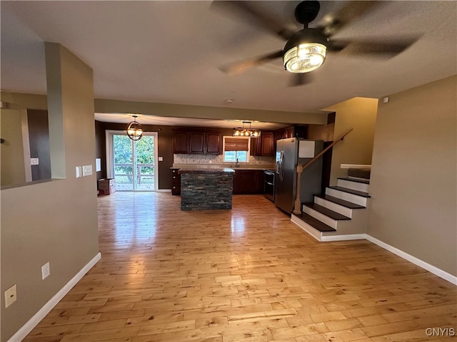 kitchen featuring backsplash, appliances with stainless steel finishes, a center island, and light wood-type flooring