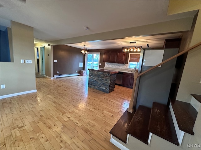 kitchen with decorative backsplash, a baseboard heating unit, stainless steel dishwasher, light hardwood / wood-style flooring, and pendant lighting