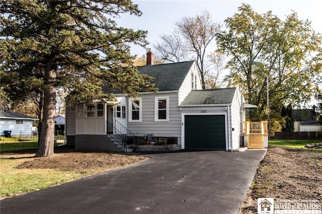 view of front of house with entry steps, an attached garage, a shingled roof, driveway, and a chimney