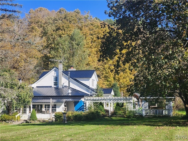 rear view of house with a yard and a pergola