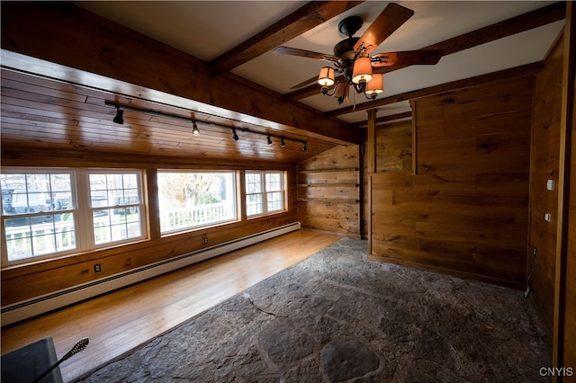 unfurnished room featuring a baseboard radiator, rail lighting, hardwood / wood-style flooring, wood walls, and lofted ceiling with beams