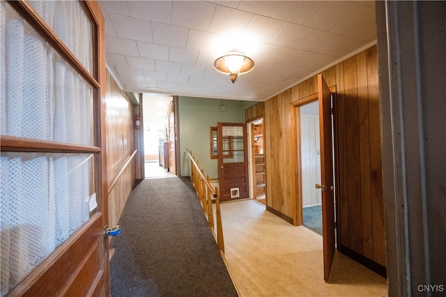 hallway with light carpet and wooden walls