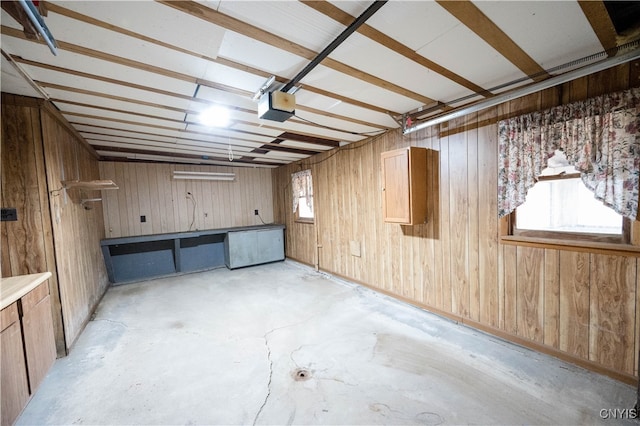 garage with a garage door opener and wood walls