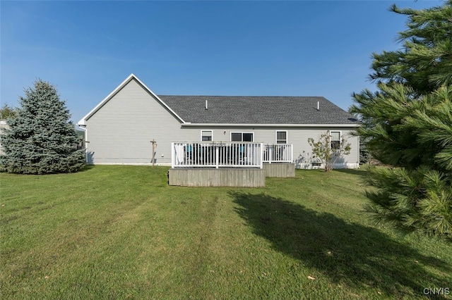 back of property featuring a deck and a lawn