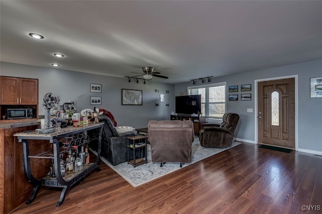 living room featuring dark wood-type flooring and ceiling fan