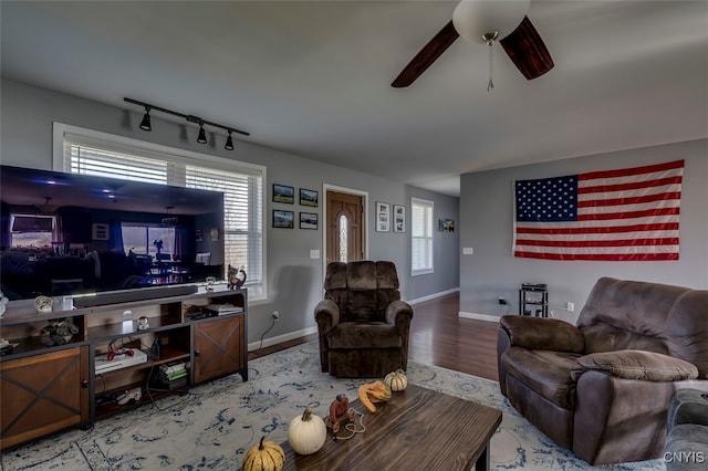 living room with plenty of natural light, hardwood / wood-style flooring, rail lighting, and ceiling fan