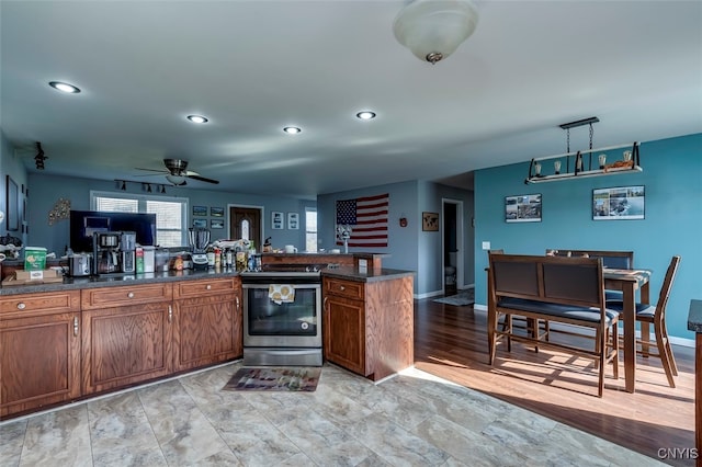 kitchen with ceiling fan, stainless steel range with electric stovetop, light hardwood / wood-style flooring, and pendant lighting