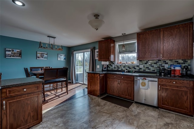 kitchen featuring sink, decorative backsplash, dishwasher, and hanging light fixtures