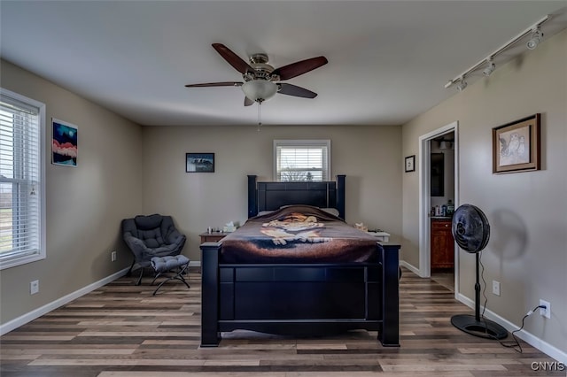 bedroom with track lighting, hardwood / wood-style flooring, and ceiling fan