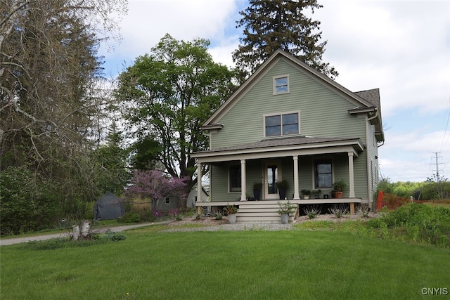 rear view of house with a porch and a lawn