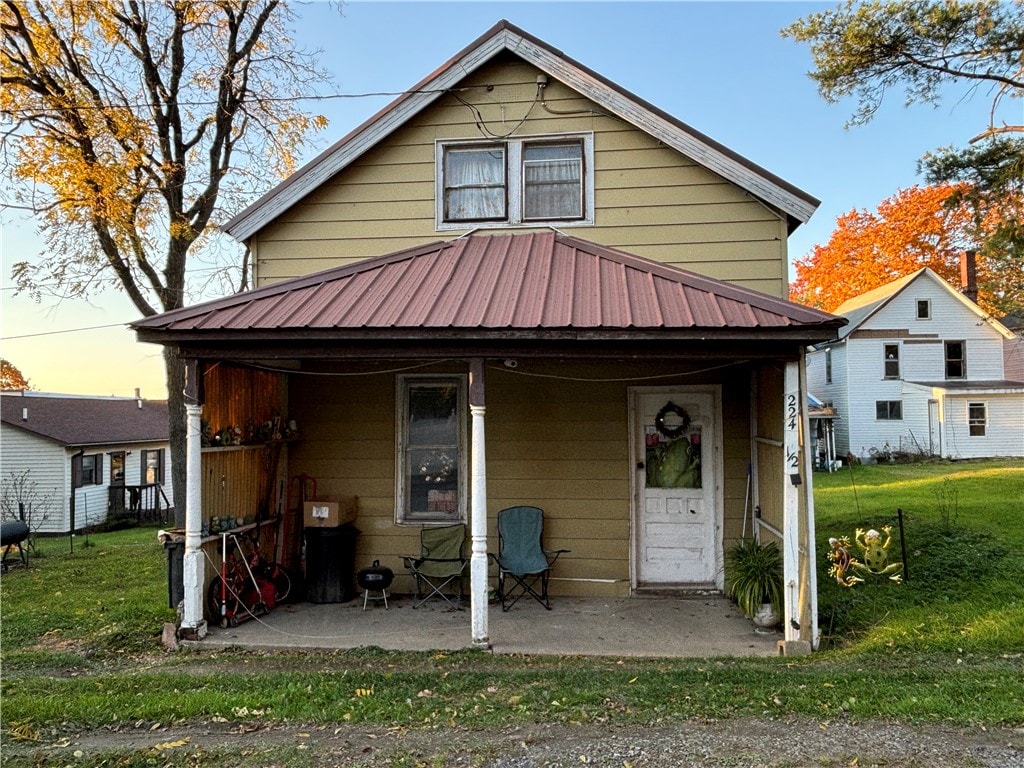 view of front of house with a lawn and a porch