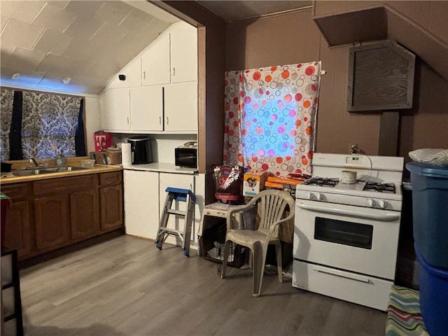 kitchen featuring light hardwood / wood-style floors, white range with gas cooktop, sink, and lofted ceiling