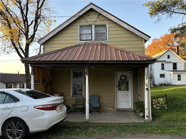 view of front of home with covered porch and a lawn