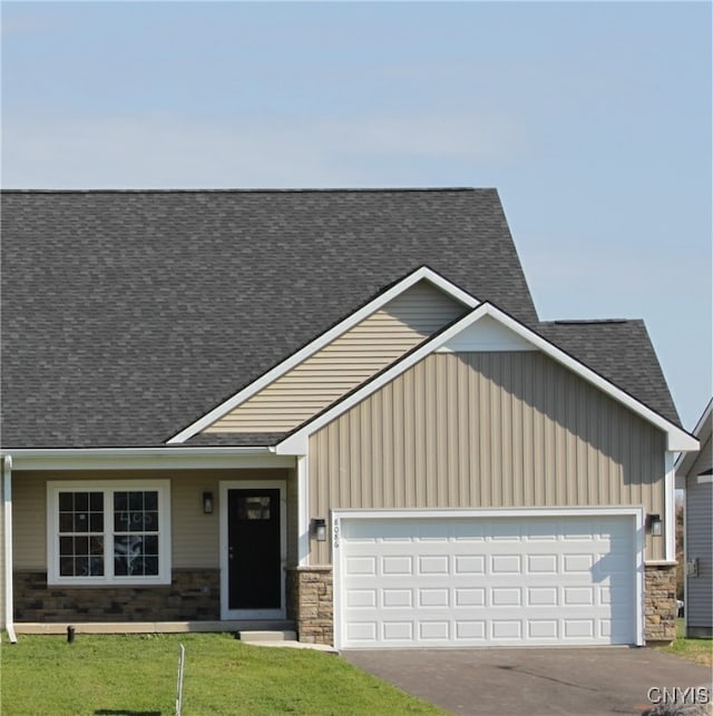 craftsman-style house featuring a front lawn and a garage