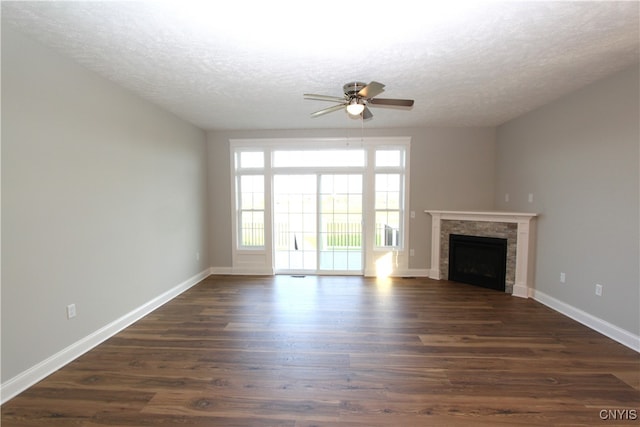 unfurnished living room with a textured ceiling, ceiling fan, a fireplace, and dark hardwood / wood-style flooring