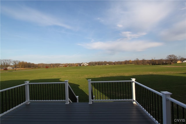 deck with a rural view and a lawn