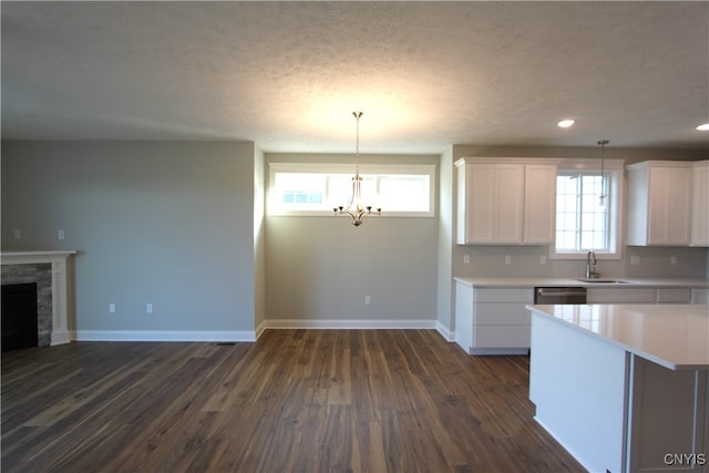 kitchen with white cabinetry, pendant lighting, a healthy amount of sunlight, and dark hardwood / wood-style flooring