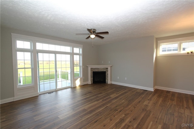 unfurnished living room featuring dark wood-type flooring, a textured ceiling, and ceiling fan