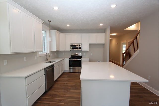 kitchen with pendant lighting, sink, white cabinetry, and stainless steel appliances