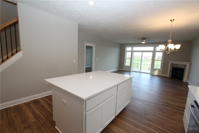 kitchen featuring dark hardwood / wood-style floors, decorative light fixtures, a kitchen island, and white cabinets