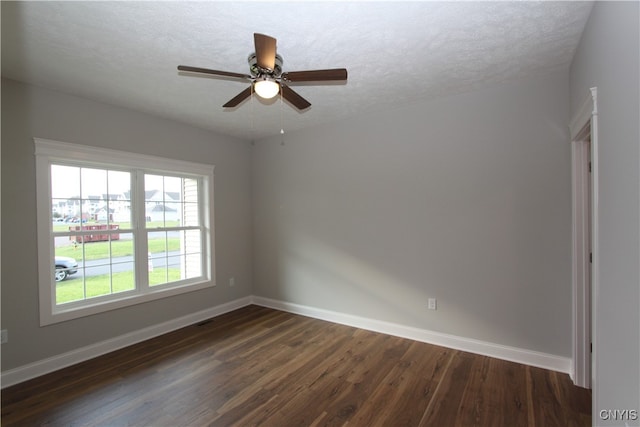 empty room with ceiling fan, a textured ceiling, and dark hardwood / wood-style flooring