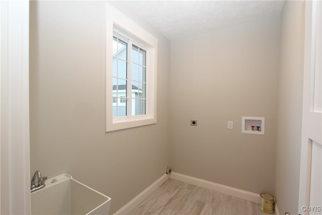 laundry area with hookup for an electric dryer, a textured ceiling, sink, and washer hookup