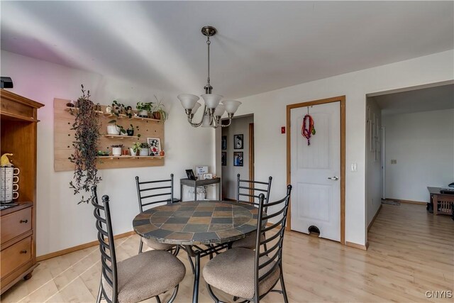 dining area featuring light hardwood / wood-style flooring and a notable chandelier