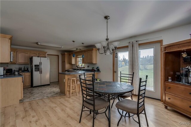 dining space with sink, a chandelier, and light hardwood / wood-style flooring