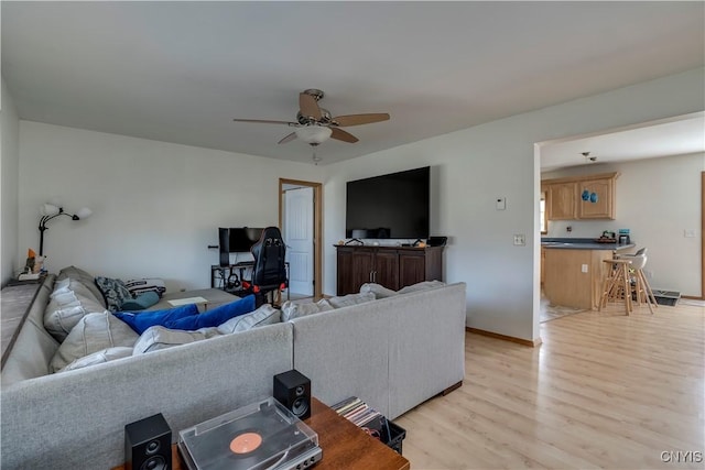 living room featuring ceiling fan and light hardwood / wood-style flooring