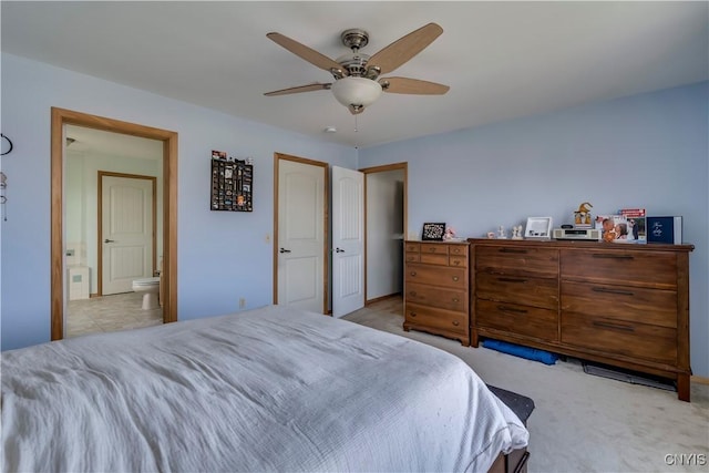 carpeted bedroom with ceiling fan and ensuite bath