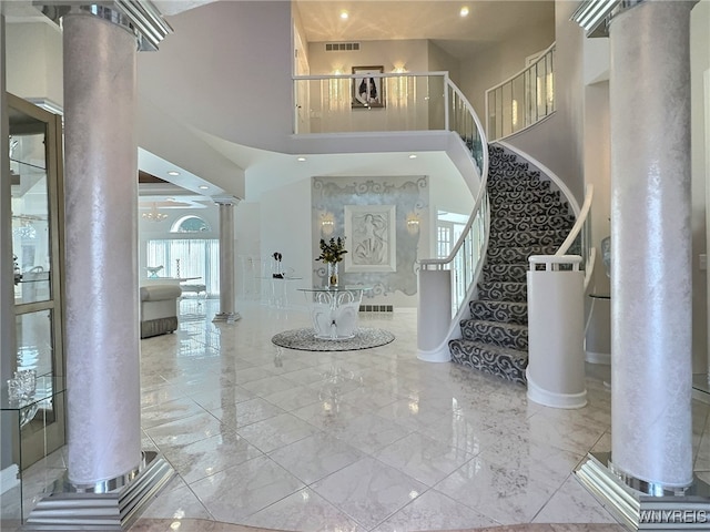 foyer featuring decorative columns and a towering ceiling