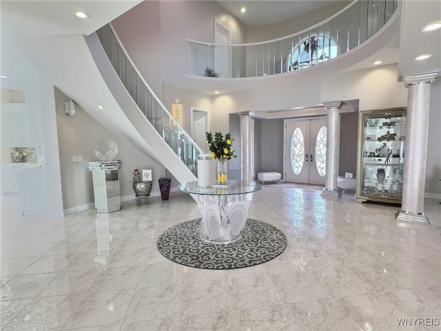 entryway featuring a towering ceiling and french doors