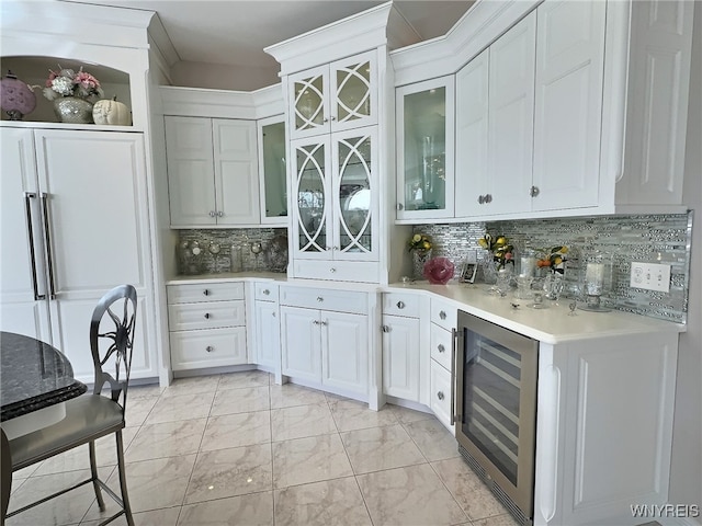 kitchen with decorative backsplash, white cabinets, high end white fridge, and beverage cooler