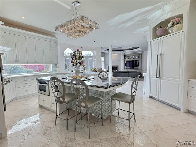 kitchen featuring oven, white cabinets, a kitchen breakfast bar, and a kitchen island