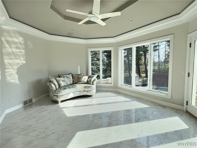 sunroom with a tray ceiling and ceiling fan